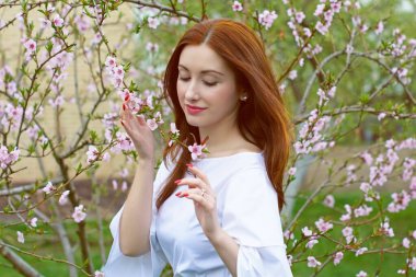 Bahar çiçekleri bahçesinde romantik bir kadın. Kadın kavramı ve şefkat, modern güzellik veya kadınlık.