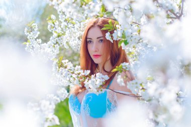 Bahar çiçekleri bahçesinde romantik bir kadın. Kadın kavramı ve şefkat, modern güzellik veya kadınlık.