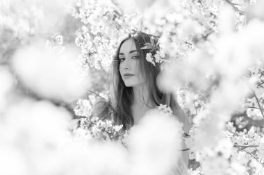 Bahar çiçekleri bahçesinde romantik bir kadın. Kadın kavramı ve şefkat, modern güzellik veya kadınlık.