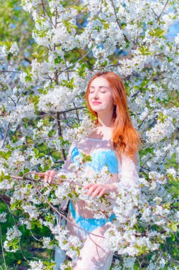 Bahar çiçekleri bahçesinde romantik bir kadın. Kadın kavramı ve şefkat, modern güzellik veya kadınlık.