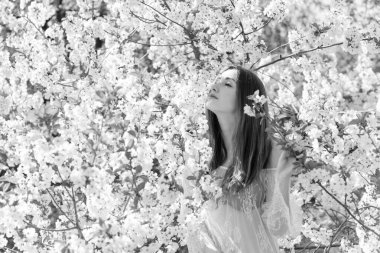 Bahar çiçekleri bahçesinde romantik bir kadın. Kadın kavramı ve şefkat, modern güzellik veya kadınlık.