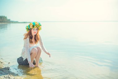 Suda dantelli beyaz elbiseli bir kadın. Nehirde başında çelenk olan bir sanat kadını. Göldeki Islak Cadı Kız, gizemli gizemli kadın. Kafasında çelenk, Slav gelenekleri ve putperestlik