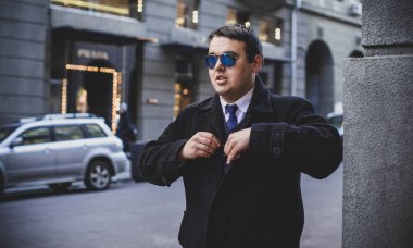 Şehir sokaklarında genç ve cüsseli bir adam, tombul insanlar konsepti, büyük şehir hayatı. Şehir merkezindeki şişman iş adamının görüntüsü