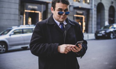 Şehir sokaklarında genç ve cüsseli bir adam, tombul insanlar konsepti, büyük şehir hayatı. Şehir merkezindeki şişman iş adamının görüntüsü