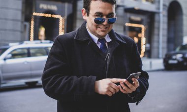 Şehir sokaklarında genç ve cüsseli bir adam, tombul insanlar konsepti, büyük şehir hayatı. Şehir merkezindeki şişman iş adamının görüntüsü