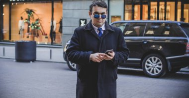 Şehir sokaklarında genç ve cüsseli bir adam, tombul insanlar konsepti, büyük şehir hayatı. Şehir merkezindeki şişman iş adamının görüntüsü