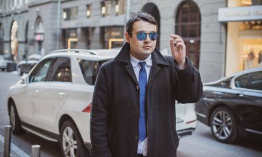 Şehir sokaklarında genç ve cüsseli bir adam, tombul insanlar konsepti, büyük şehir hayatı. Şehir merkezindeki şişman iş adamının görüntüsü