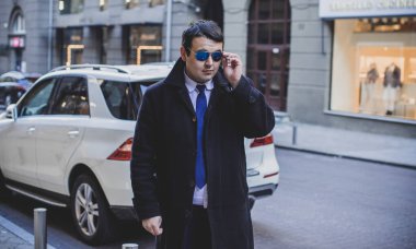 Şehir sokaklarında genç ve cüsseli bir adam, tombul insanlar konsepti, büyük şehir hayatı. Şehir merkezindeki şişman iş adamının görüntüsü