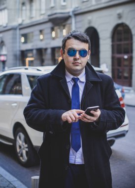 Şehir sokaklarında genç ve cüsseli bir adam, tombul insanlar konsepti, büyük şehir hayatı. Şehir merkezindeki şişman iş adamının görüntüsü