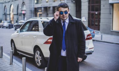 Şehir sokaklarında genç ve cüsseli bir adam, tombul insanlar konsepti, büyük şehir hayatı. Şehir merkezindeki şişman iş adamının görüntüsü