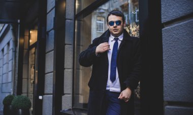 Şehir sokaklarında genç ve cüsseli bir adam, tombul insanlar konsepti, büyük şehir hayatı. Şehir merkezindeki şişman iş adamının görüntüsü