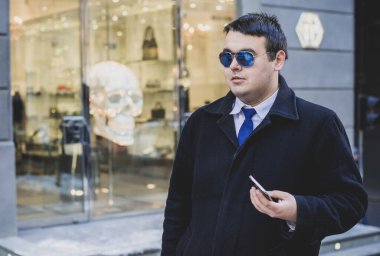 Şehir sokaklarında genç ve cüsseli bir adam, tombul insanlar konsepti, büyük şehir hayatı. Şehir merkezindeki şişman iş adamının görüntüsü