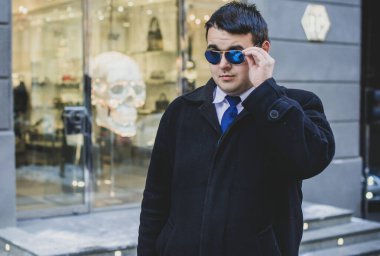 Şehir sokaklarında genç ve cüsseli bir adam, tombul insanlar konsepti, büyük şehir hayatı. Şehir merkezindeki şişman iş adamının görüntüsü