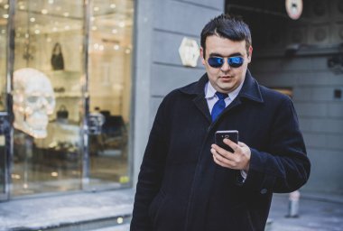 Şehir sokaklarında genç ve cüsseli bir adam, tombul insanlar konsepti, büyük şehir hayatı. Şehir merkezindeki şişman iş adamının görüntüsü