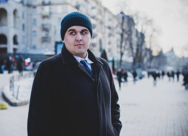 Şehir sokaklarında genç ve cüsseli bir adam, tombul insanlar konsepti, büyük şehir hayatı. Şehir merkezindeki şişman iş adamının görüntüsü