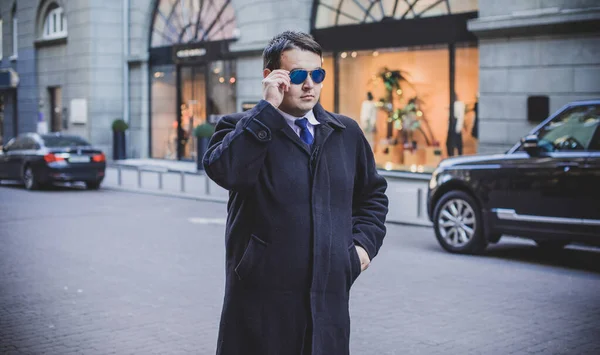 Young plus size man in city streets, plump people concept, one in big city life. Image of overweight businessman at downtown