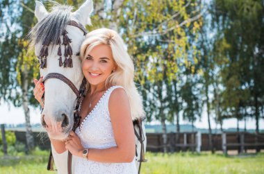 Atı ile konuşan zarif bir kadın. Bir kadınla ata binmenin portresi. Doğası gereği binicisi olan bir at.