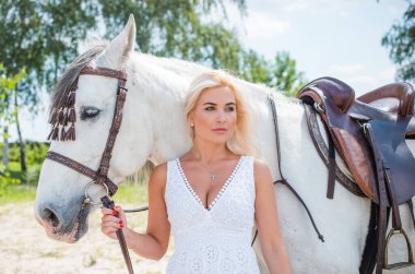 Atı ile konuşan zarif bir kadın. Bir kadınla ata binmenin portresi. Doğası gereği binicisi olan bir at.