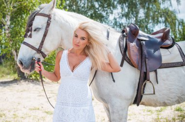 Atı ile konuşan zarif bir kadın. Bir kadınla ata binmenin portresi. Doğası gereği binicisi olan bir at.