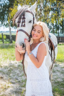 Atı ile konuşan zarif bir kadın. Bir kadınla ata binmenin portresi. Doğası gereği binicisi olan bir at.