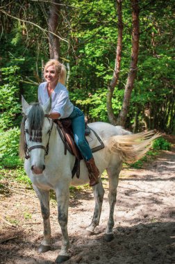 Atı ile konuşan zarif bir kadın. Bir kadınla ata binmenin portresi. Doğası gereği binicisi olan bir at.