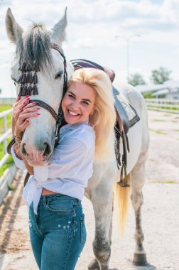 Atı ile konuşan zarif bir kadın. Bir kadınla ata binmenin portresi. Doğası gereği binicisi olan bir at.