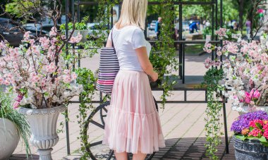 Şık giyinen genç sarışın kadın şehir sokaklarında yürüyor, şık bir bayan, moda. Artı sokaktaki boy modeli.