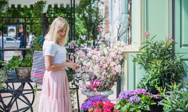 Şık giyinen genç sarışın kadın şehir sokaklarında yürüyor, şık bir bayan, moda. Artı sokaktaki boy modeli.