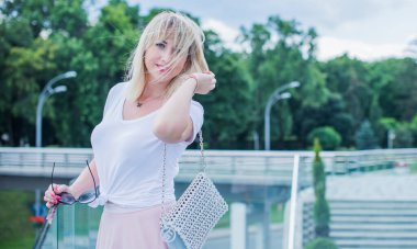 Şık giyinen genç sarışın kadın şehir sokaklarında yürüyor, şık bir bayan, moda. Artı sokaktaki boy modeli.