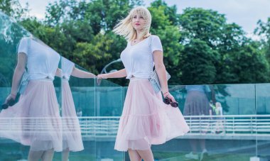 Şık giyinen genç sarışın kadın şehir sokaklarında yürüyor, şık bir bayan, moda. Artı sokaktaki boy modeli.