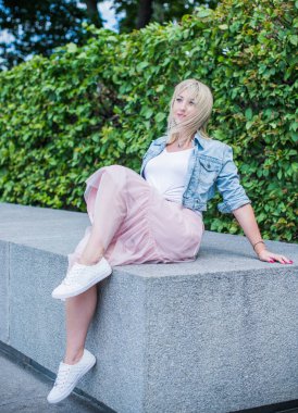 Şık giyinen genç sarışın kadın şehir sokaklarında yürüyor, şık bir bayan, moda. Artı sokaktaki boy modeli.