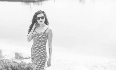 Puantiyeli elbise giymiş genç güzel bir kadının moda retro tarzı portresi. Retro (antika) bir bayan portresi. Elbiseli genç kızın portresini iğnele.