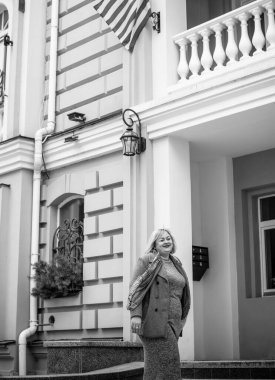 Büyük beden, Amerikan ya da Avrupa görünümlü bir kadın şehir sokaklarında hayatın tadını çıkararak yürüyor. Fazla kilolu genç bir bayan, şık bir elbise giyiyor. Doğal güzellik.