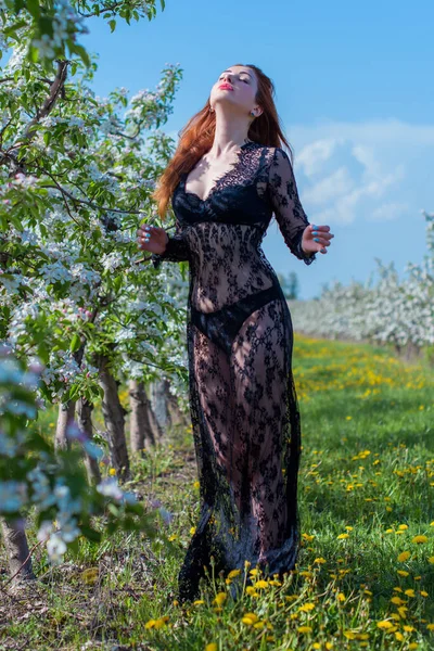 Bahar çiçekleri bahçesinde dantel elbiseli romantik bir kadın. Şefkat ve modern kadınlık kavramı