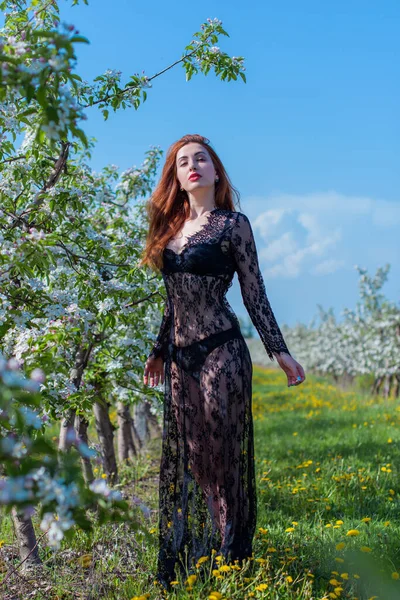Bahar çiçekleri bahçesinde dantel elbiseli romantik bir kadın. Şefkat ve modern kadınlık kavramı