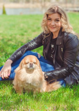 Güzel, sarışın bir kadın. Sokakta köpeği, doğal güzelliği, modern bir bayanı var. Ben veya XI beden, artı beden modeli.