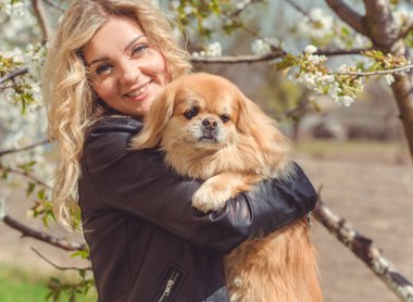 Güzel, sarışın bir kadın. Sokakta köpeği, doğal güzelliği, modern bir bayanı var. Ben veya XI beden, artı beden modeli.