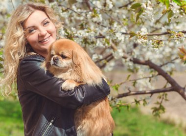 Güzel, sarışın bir kadın. Sokakta köpeği, doğal güzelliği, modern bir bayanı var. Ben veya XI beden, artı beden modeli.
