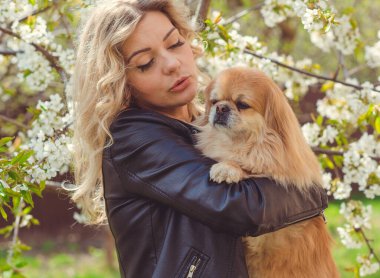 Güzel, sarışın bir kadın. Sokakta köpeği, doğal güzelliği, modern bir bayanı var. Ben veya XI beden, artı beden modeli.
