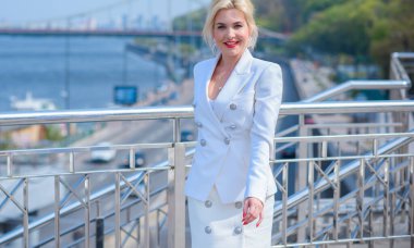 Woman in white jacket and skirt at street, woman outfit. Business and Fancy style for ladies, fashion details