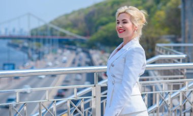 Woman in white jacket and skirt at street, woman outfit. Business and Fancy style for ladies, fashion details