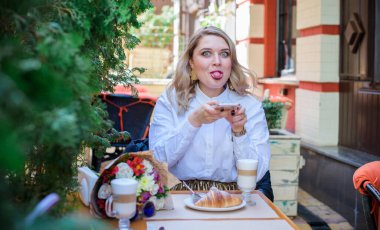 A woman of plus size, American or European appearance walks at city streets enjoying life. A young lady with excess weight, have a stylish dress. Natural beauty