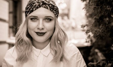 A woman of plus size, American or European appearance walks at city streets enjoying life. A young lady with excess weight, have a stylish dress. Natural beauty