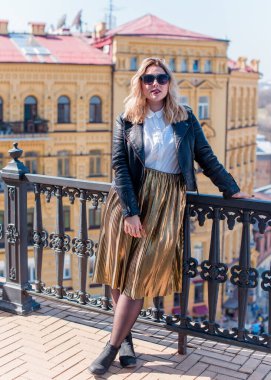 Young stylish woman walking on the city street at spring . Casual fashion modern look. Plus size model. Happy overweight woman walking the city streets