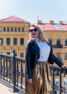 Young stylish woman walking on the city street at spring . Casual fashion modern look. Plus size model. Happy overweight woman walking the city streets