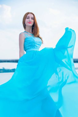 Nehirde uzun ve güzel uçan elbisesi olan muhteşem Hintli kadın..