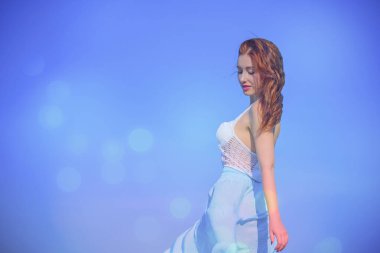 Rahat ol. Şık vücutlu bir kadın doğada dinleniyor, çekici kızıl saçlı bayan tatildeki hayatın tadını çıkarıyor.