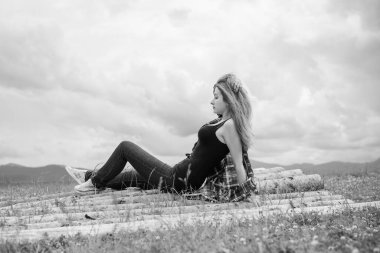 Tatil konsepti. Neşeli kadın uçurumun kenarında dinleniyor ve vadiye ve dağlara bakıyor. Dağlarda seyahat, özgürlük ve aktif yaşam tarzı konsepti