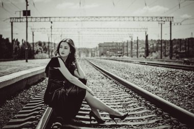 Eski sinema tarzı. Platformda bavulu olan yeşil kadife elbiseli güzel bir kızıl kadın.