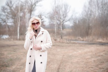 Beyaz kürklü kadın ceketi, leopar atkısı, kedi gözü gözlükleri, sarışın hoş bayan portresi, moda konsept.